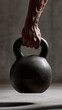 © Daria - Muscular hand gripping a heavy black kettlebell for strength training against a moody neutral background with dramatic lighting effects