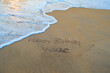 © DreamLayer - Custom Birthday Wish Background Showing 'Happy Birthday Wuze' Written on Sandy Ocean Shore as Sea Waves Roll In