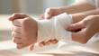 © lnsu - Close view of a wrist being dressed with cotton gauze