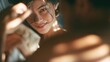 © IMAJI - Young smiling woman looking at partner closely in soft sunlight indoors