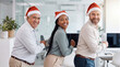 © Pei - Three diverse businesspeople in Santa hats dance with eye contact in a modern office for joyful Christmas internal celebration imagery.