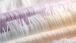 © ernawatima - Close-up of neatly arranged spools of silky thread in soft pastel pink, white, and blue tones, showcasing delicate fibers and smooth textures.