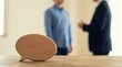 © MdNazim - Wooden speech bubble on a rustic wooden table with blurred business colleagues talking in the background