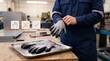 © mudassar - Worker putting on protective gloves at a workbench in a manufacturing facility workshop setting