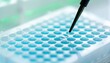 © FauziNh - A laboratory pipette dispenses a liquid into a well plate.