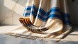 © MSTMAYA - Ceremonial shofar horn placed on folded silk tallit prayer shawl with blue stripes on marble surface for jewish holy day religious rituals