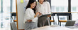 © David - Businesswomen collaborating on a project, analyzing data and discussing strategy in a modern office meeting, working together to achieve common goals and reviewing documents