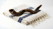 © Al - Traditional Jewish Shofar horn resting on a white and blue prayer shawl