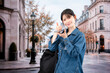 © maroke - 海外旅行をしながらAIで調べ物をする若い女性