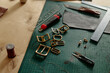 © Westend61 - Leatherworking tools and brass buckles lie on a workshop table