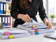 © Mo - Professional businesswoman organizing documents and paperwork at her desk in a modern office