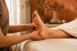 © Olena - Wellness therapist gently massaging a client's foot in a warm spa setting, representing reflexology, relaxation, foot care, therapeutic massage, wellness treatment and self-care.