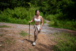 © Apichat - Woman Hiking in Nature Wilderness with Walking Stick and Casual Attire