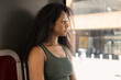 © ADDICTIVE STOCK - Thoughtful woman in green top by urban window