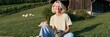© Andrii Zastrozhnov - Woman sitting on a sunny hillside holding fresh vegetables for rural farm lifestyle background and sustainable living banner