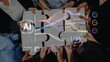 © InfiniteFlow - Hands of a diverse group come together to solve challenges related to artificial intelligence, showcasing colorful puzzles and insightful data metrics in a modern workspace. Raster