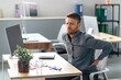 © Prostock-studio - Worried Man, Caucasian, Adult, Experiencing Back Pain While Sitting At His Office Desk With A Computer, Holding Lower Back, Workplace, Business Concept.