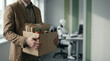 © Jai Izzam - Faceless employee packing cardboard box looking at robotic artificial intelligence taking over corporate desk job