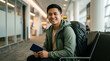 © SUMIDAH - Smiling young man with a backpack waiting comfortably at an airport terminal