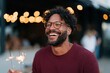 © Iryna - Laughing man holding handheld sparklers with bokeh lights in evening for festive celebration background and candid portrait banner design