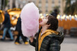 © Westend61 - Boy in jacket eating pink cotton candy at outdoor market