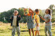© standret - Children Playing with Floating Soap Bubbles in Sunlit Meadow, Diverse Group Outdoors During Summer, Joyful Childhood Scene with Trees and Grass