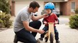 © Cahya - Father kneeling to adjust blue helmet chin strap and knee pads on his young son riding wooden balance bike symbolizing paternal care and child bike safety training