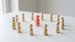 © Dudu - Wooden figurines joined to central red leader by white threads represent social network connectivity organizational unity concept.