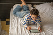 © iwavephoto - Teenage boy holding tablet and digital pen at home, sketch made with thin digital pen, frame worth keeping in whole collection. Wide shot. Concept of digital drawing on tablet at home