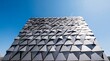 © Micah - Modern architectural facade with triangular metal plates for sustainable climate control and stylish building exterior view.