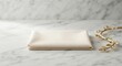 © Ірина Агібалова - Cream folded napkin and golden leaf ornament on elegant white marble tabletop
