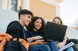 © Breezze - Students with a laptop sitting on campus steps, showing genuine smiles and a collaborative energy for education and digital learning