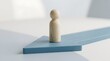 © staysteel - Minimalist wooden peg figure standing on a blue directional arrow representing strategic business direction and simple leadership concept