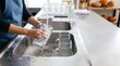 © Bay - Person cleaning beer steins at a kitchen sink