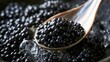 © 69 - Close-up of black fish roe with shiny texture served on a wooden spoon over crushed ice with dark background for fresh seafood concept