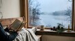 © Abdur - A person reading a book while sitting by a window overlooking a misty winter lake