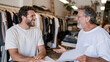 © CinimaticWorks - cheerful shop owner and a mature man discussing an order in a fashion boutique representing small business management and a positive partnership in retail