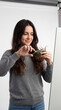 © ENDRY - Smiling woman cuts own hair.