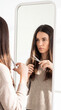 © ENDRY - Woman cuts own hair in mirror.