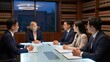 © Leon - Professionals discuss legal strategy around a glass table surrounded by bookshelves filled with law books.