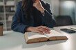 © Phimwilai - Woman studying book, learning and concentrating at desk