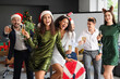 © Pixel-Shot - Corporate christmas party, diverse colleagues celebrating with champagne and festive accessories in modern office environment during holiday season