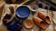© edo - Handcrafted souvenirs flat lay golden cup geometric blue plate floral orange leather slippers textured fabric traditional Moroccan architecture i