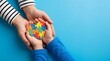 © EtiAfrose - Autism awareness heart puzzle piece in hands of adult and child symbolizing support and love
