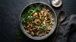 © bp - Top view of a rustic stoneware bowl filled with healthy grains sauteed mushrooms kale and roasted hazelnuts set against a dark textured stone slate surface with a wooden spoon and seasoning bowls.