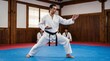 © Cahya - Taekwondo black belt master demonstrating knife-hand block stance on mat in traditional dojang hall depicting martial arts discipline, combat posture, and self defense practice
