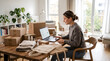 © Fiverr/fazilazia703 - young female small business owner working on laptop computer at wooden dining table with cardboard packages tote bags and cosmetic jars for online ecommerce order packaging and fulfillment