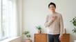 © 3AN - Kind Asian man placing his hand on his heart with a sincere grateful smile in a bright modern room.