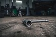 © kamyuga - Low angle wide shot of a steel spark plug socket wrench with extension bar lying on an auto repair shop concrete floor
