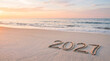 © Parvej - The year 2027 written in the sand on a beautiful tropical beach at sunrise